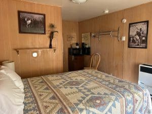 Interior of a motel room with a bed, wall art, and basic amenities in Meeteetse, Wyoming.